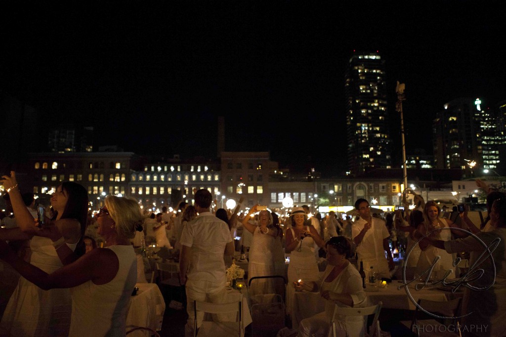 Guests waving sparklers at Diner En Blanc event in Toronto. 